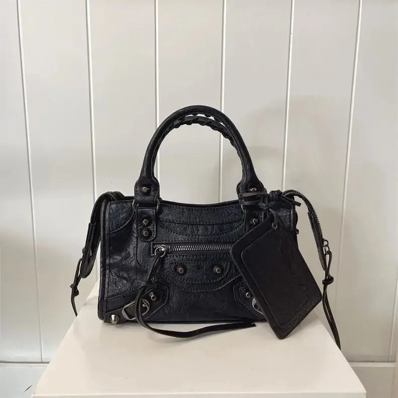 Black handled bag listing image showing zips, studs, strap, and tag